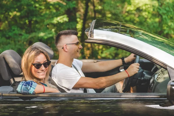 Güzel çift doğada cabriolet araba sürüş tarafından tatile gitmek.