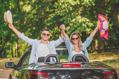 Eller yukarı cabriolet araba ile çift. Yol yolculuk seyahat konsepti.