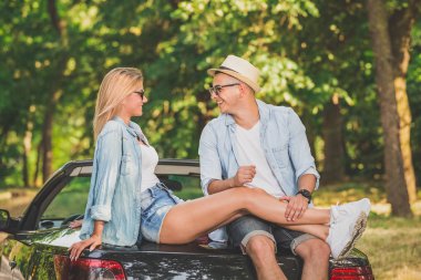 Aşık doğada kendi Cabrio araba arkasında oturan genç çift.