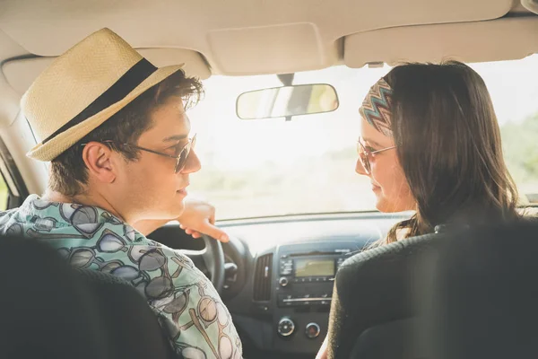 Güzel genç bir çift aşık arabada oturuyor. Yol seyahat konsepti üzerinde.