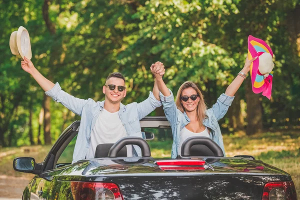 Eller yukarı cabriolet araba ile çift. Yol yolculuk seyahat konsepti.