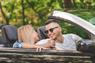 Güzel çift doğada cabriolet araba sürüş tarafından tatile gitmek.