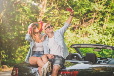 Cabriolet gövde üzerinde oturan ve kendi kendine portre çekici şık çift.