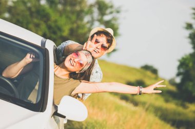Mutlu çift araba penceresinden ile doğa eller yukarı. Yol konsepti üzerinde seyahat.