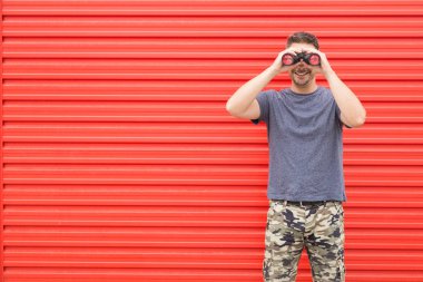 Hipster kırmızı arka plan üzerinde dürbün.