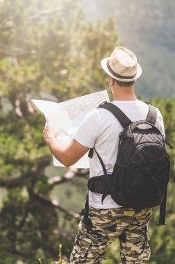 Backpacker dağın tepesinde harita ile