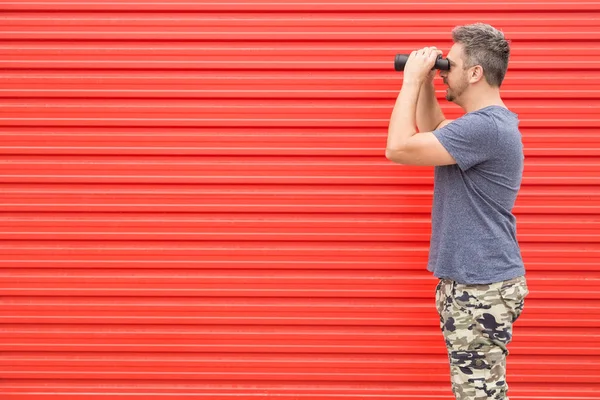 Hombre Moderno Mirando Través Binoculares Contra Pared Metal Rojo — Foto de Stock
