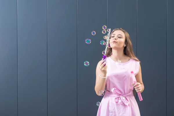 Hermosa Joven Que Sopla Burbujas Jabón Contra Fondo Gris Espacio — Foto de Stock