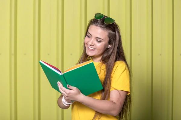 Portret Dziewczynki Książką Tle Żółty Metalowe Ściany Koncepcja Edukacji — Zdjęcie stockowe