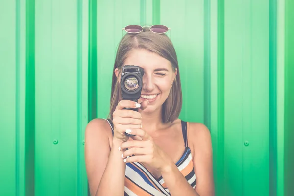 緑の背景に分離されたレトロなカメラで撮影笑顔の若い女性の肖像画 — ストック写真
