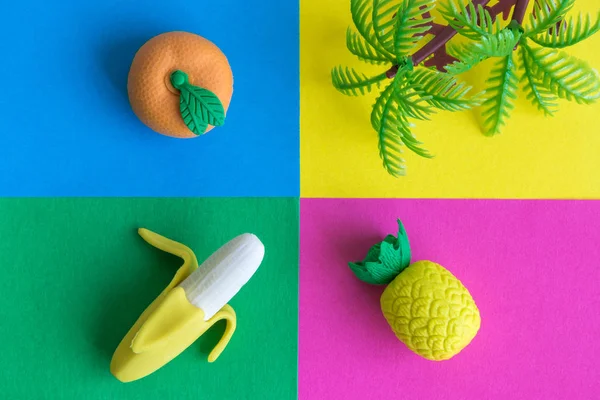 热带橡胶果子和塑料棕榈树在五颜六色的背景 — 图库照片