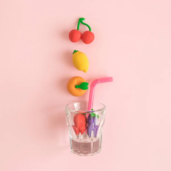 Colocação Plana Brinquedos Frutas Caindo Copo Beber Fundo Rosa Pastel — Fotografia de Stock