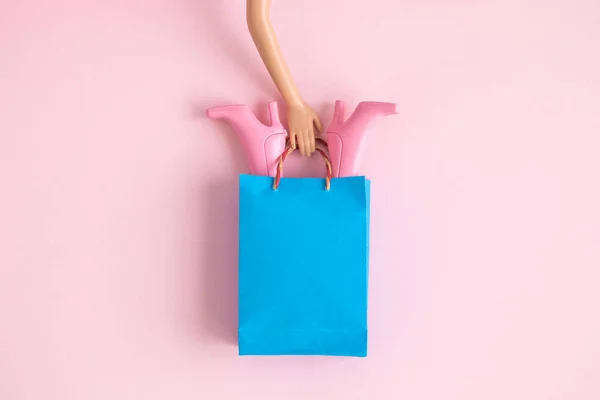 Flat Lay Mão Boneca Segurando Saco Compras Papel Com Botas — Fotografia de Stock