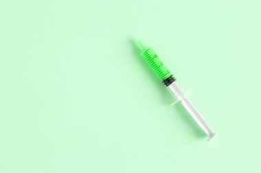 Düz şırınganın izole yeşil arka plan en az yaratıcı kavramı üzerinde yatıyordu. Kopya için alan.