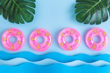 Monstera palmiye yaprakları ve pastel mavi gökyüzü arka plan en az yaratıcı kavramı karşı dalgalar deniz havuzu düz lay yüzer. Kopya için alan.