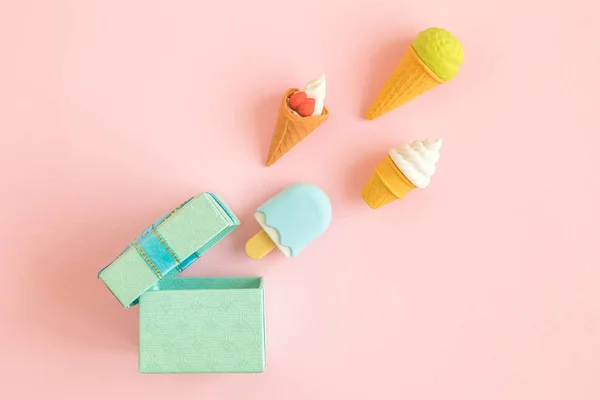 在柔和的粉红色背景隔离的冰淇淋玩具和礼品盒抽象平躺. — 图库照片