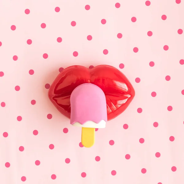 Plochý lay plastových rty a zmrzliny hračkou abstrakt na pozadí růže polka. — Stock fotografie