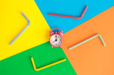 Çok renkli arka plan yaz üzerinde çalar saat ve içme pipı soyut.