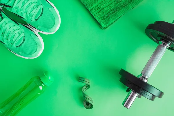 Zöldre elszigetelt sporteszközök az egészséges életmód koncepcióján. — Stock Fotó