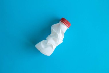 Mavi plastik şişe soyut ve düz lay.