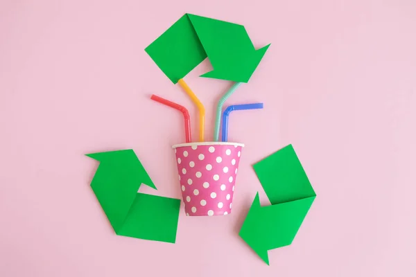 Flat lay of disposable cup with drinking straws and recycling symbol made of paper abstract. — Stock Photo, Image
