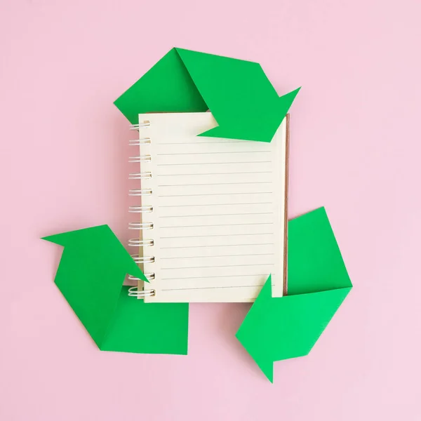 Flat lay de notebook e ícone de reciclagem feita de papel abstrato. Espaço para cópia . — Fotografia de Stock