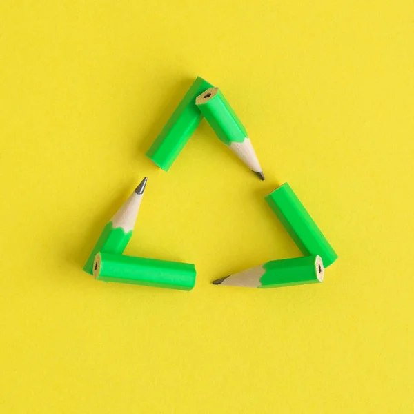 Grüne Bleistifte in Form von Recycling-Zeichen abstrakt. — Stockfoto