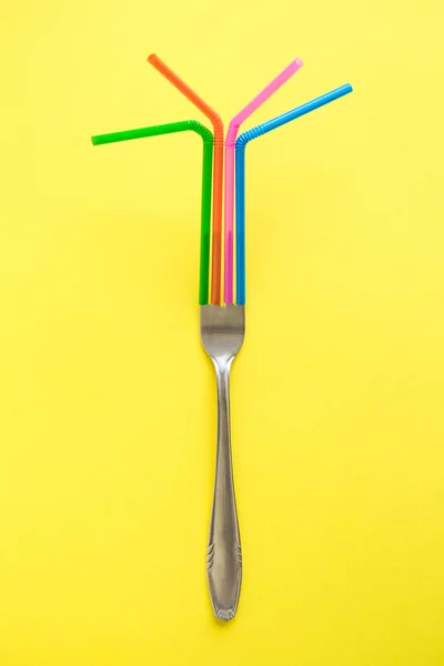 Tenedor y beber pajitas abstracto sobre fondo amarillo . — Foto de Stock