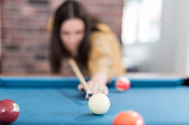Şık kadın bilardo havuzu snooker işareti ile beyaz topa vurmaya hazırlanıyor.