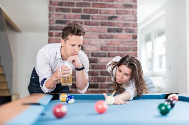 Ofis chill room bilardo masası bilardo oyunu oynayan güzel moda çift.