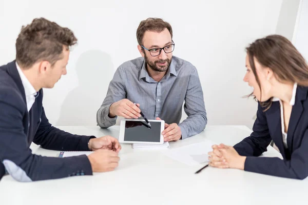 Három üzletemberek látszó-on üres képernyő tabletta berendezés rövid idő ülő-nél iskolapad-ra egy találkozó. — Stock Fotó