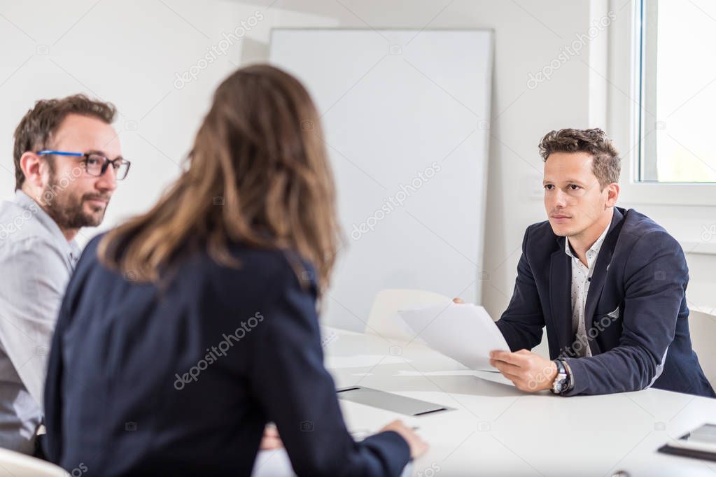 Business partners sitting at the desk in conference room and discussing