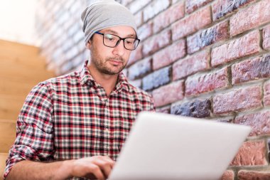 Moda freelancer dizüstü klavye elleri ile ofis binasında merdivenlerde oturan.