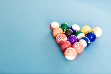 Bilardo masasında üçgen şekil oluşturan snooker topları.