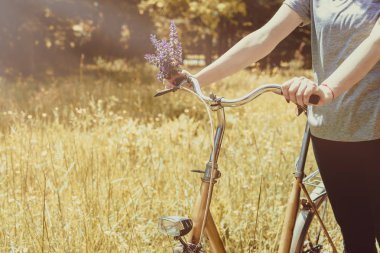 Doğada Vintage Bisiklet gidon üzerinde kadın eller. İlkbahar veya yaz sezonu konsepti.