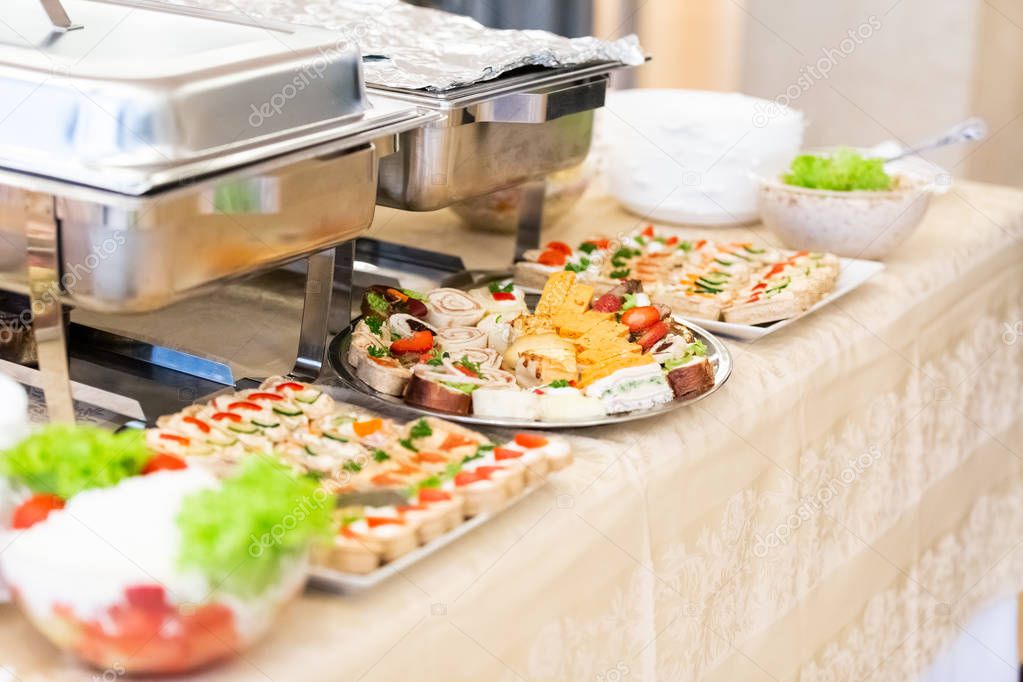 Canapes and salads on buffet table.