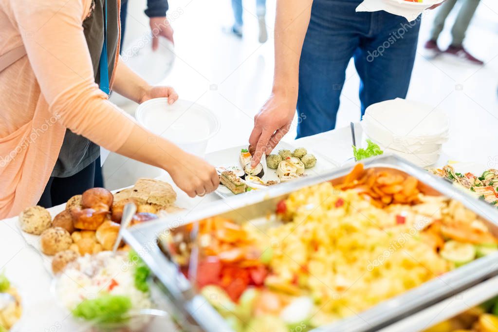 Female hands picking up food from platter. Event wedding buffet concept.