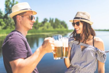 Doğada bira bardaklarıyla tezahürat yapıyor güzel bir çift. Yaz tatili ve parti konsepti.