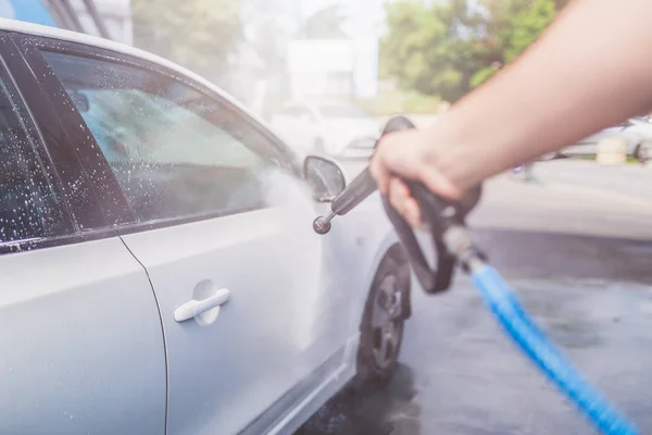 Wassen moderne auto met druk water in carwash. — Stockfoto