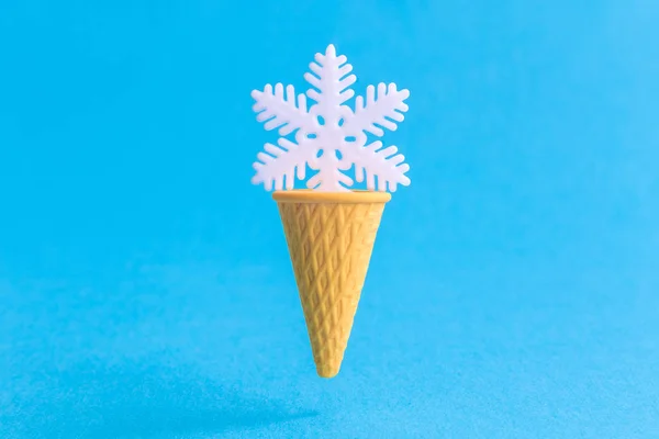 Close-up van ijskegel met witte sneeuwvlok geïsoleerd op blauw. — Stockfoto