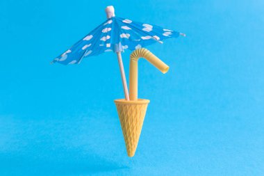 Dondurma konisi soyut mavi izole saman ve kağıt şemsiye içme.