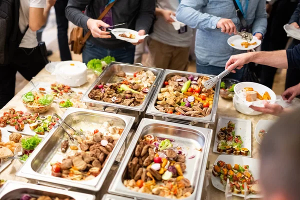 Yemeği kepçeyle savuruyor. Restoranda açık büfe yemek. Catering gıda.