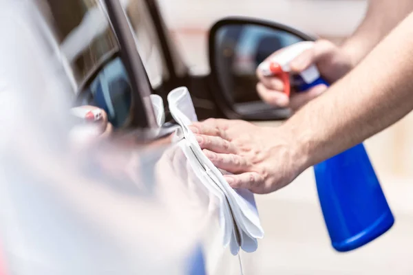 Hombre manos limpieza y esterilización exterior del coche . — Foto de Stock