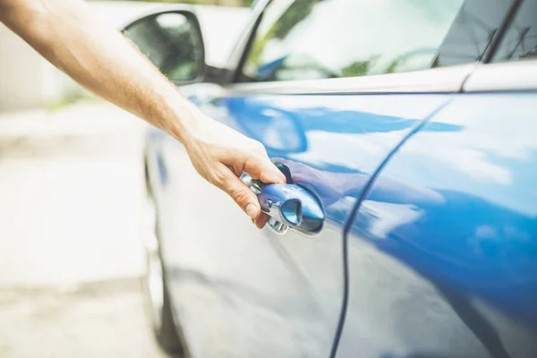 Close-up van man opening deur van blauwe voertuig. — Stockfoto