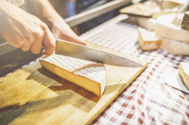 Tarım fuarı standında yaşlı peynirin kesilmesi.