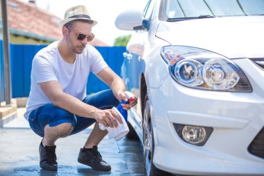 Bez ve sprey şişesi ile araba tekerleği temizlik Adam.