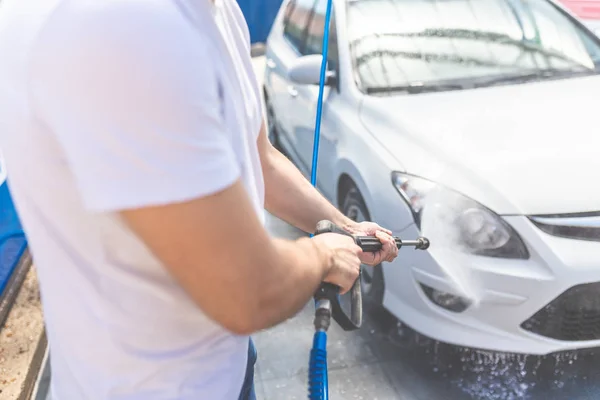 Close-up de lavagem manual do carro com pulverização de água pressurizada na lavagem do carro . — Fotografia de Stock