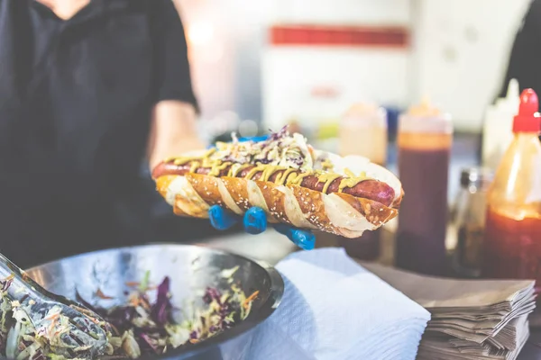 Man holding hot dog. Street fast food vendor concept.