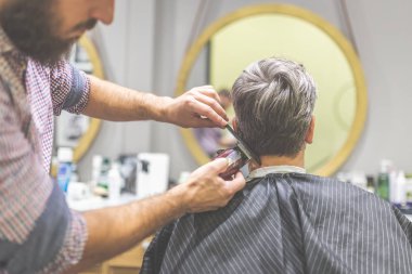 Profesyonel berber tarak ve makas kullanarak müvekkilinin saç şekillendirme.