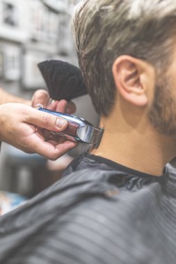 Profesyonel berber makas ve fırça kullanarak müvekkilinin saç şekillendirme.